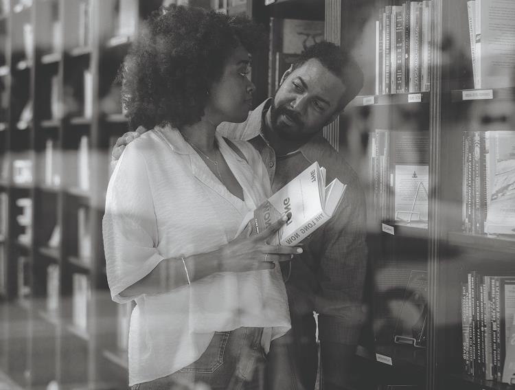 Man and woman look at each other in library